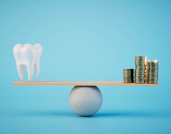 A balance beam on which a tooth and stacks of coins are placed