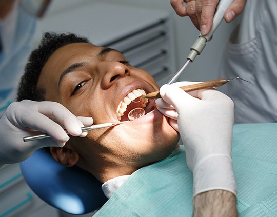 A young man having a thorough teeth cleaning