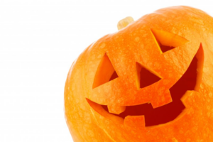 Close up of a pumpkin that’s carved out to have a classic 4-tooth smile